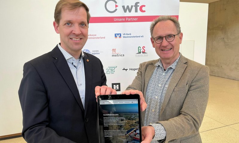 Einfach scrollen: Landrat Dr. Christian Schulze Pellengahr (links) und wfc-Geschäftsführer Dr. Jürgen Grüner zeigen den Rückblick auf das Wirtschaftsjahr 2022 im Kreis Coesfeld im neuen multimedialen Geschäftsbericht der wfc. Foto: wfc