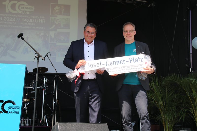Ahlens Bürgermeister Dr. Alexander Berger (links) übergab ein ganz besonderes Präsent an Jürgen Henke: das Straßenschild für den künftigen „Josef-Renner-Platz“.