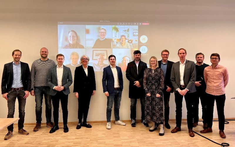 Das Bewerberkonsortium „NortH2West Mobility“ mit den Vertreterinnen und Vertretern der beteiligten Landkreise, Städte und Firmen (von links): Dr. Tim Husmann (H2-Region Emsland), Henning Bückers (Kreis Steinfurt), Daniel Schaschkewitz (Kreis Warendorf), Petra Michalczak-Hülsmann (Kreis Warendorf), Jonas Lorenz (H2-Region Emsland), Rüdiger Schuma (Krimphoff & Schulte Mineralöl-Service u. Logistik GmbH), Katharina Krimphoff (Kreis Borken), Stephan Griesehop (Landkreis Grafschaft Bentheim), Michael Weitzell (Kreis Borken), Sebastian Niehoff (BEN-Tec GmbH), Michael Barkmann (Stadtwerke Gronau); per Video dazugeschaltet (v.l.o.n.r.u.): Daniela Terbeck (Wasserstoff-EntwicklungsGmbH & Co. KG), Stefan Bölte (Kreis Coesfeld), Johanna Martin (GP Joule), Jens Bischoff (Kreis Coesfeld), Thorsten Wulff (Nikola Corporation), Sebastian Freund (Nikola Corporation); Foto: Esther Gebert, H2-Region Emsland