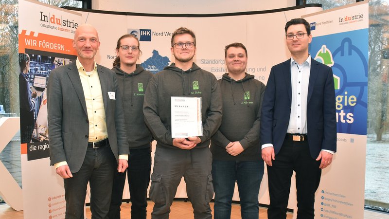 IHK-Referent Thorsten Hahn (rechts) und Jurymitglied Ralf Swetlik (links) von der Initiative In|du|strie gratulierten den Energie Scouts von Windmöller & Hölscher zum Gewinn: Der angehende Elektroniker Tobias Kretschmer und die beiden Fachinformatik-Azubis Marius Dohe und Jonas Aßmann (von links) überzeugten mit ihrem Projekt „GreenTeam“. Foto: Hertel/IHK 