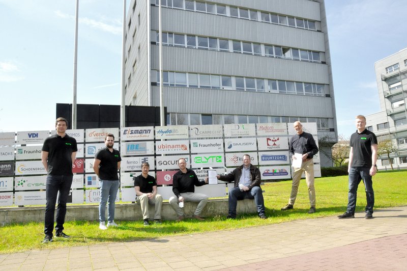 TFM-Geschäftsführer Enno Fuchs und TFM-Geschäftsleiter Matthias Günnewig owie Dr. Kolja Beltrop nd weitere Mitglieder des E-Lyte-Teams präsentieren den neuen Mietvertrag.