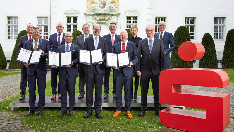 Haben den Vertrag für die gemeinsame Sparkasse Münsterland Ost unterzeichnet (vorne von links): Waderslohs Bürgermeister Christian Thegelkamp, Beckums Bürgermeister Michael Gerdhenrich, Warendorfs Landrat Dr. Olaf Gericke und Münsters Oberbürgermeister Markus Lewe mit Jürgen Rühl, dem Vorsitzenden der bisherigen Zweckverbandsversammlung der Sparkasse Beckum-Wadersloh, sowie (hinten von links) Dr. Stefan K. Bürger (Sparkasse Beckum-Wadersloh), Peter Scholz (Sparkasse Münsterland Ost), Klaus Richter (Sparkasse Münsterland Ost), Jürgen Wenning (Sparkasse Beckum-Wadersloh), Dr. Annegret Saxe (Sparkasse Münsterland Ost) und Roland Klein (Sparkasse Münsterland Ost). Foto: Sparkasse Münsterland Ost
