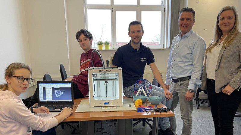 Das Modell am PC entwerfen und das Bauteil dann am 3D-Drucker fertigen: Alma Wissing und Jona Oestermann (von links) nahmen am Dualen Orientierungspraktikum teil und absolvierten ihre betriebspraktischen Tage bei Flender unter Anleitung von Tobias Degeling und Thorsten Fahrland. Jennifer Middelkamp vom Unternehmerverband hatte diese besondere Berufsorientierung für insgesamt 17 Schülerinnen und Schüler gemeinsam mit der WFG des Kreises organisiert. Foto: Unternehmerverband