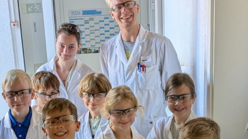 Ausgestattet mit Laborkitteln ging es für die Kinder zusammen mit den ALS Azubis Pia Huchtkemper und Marlon Heymann auf Entdeckungstour durch die Welt der Wissenschaft. Foto: ALS Germany GmbH