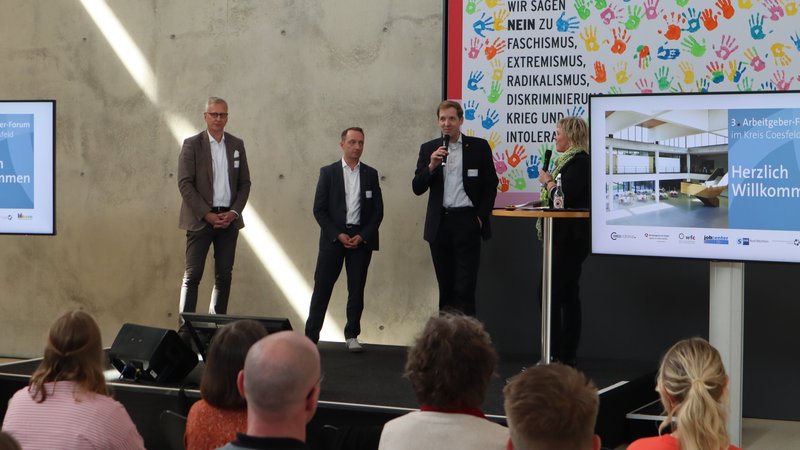 Horst Beeck (CFO von Ernsting’s Family), Frank Thiemann (Leiter der Agentur für Arbeit Coesfel und Dr. Christian Schulze Pellengahr (Landrat des Kreises Coesfeld, von links.) eröffneten mit Moderatorin Julia Roesler das 3. Arbeitgeberforum im Kreis Coesfeld. Foto Agentur für Arbeit Coesfeld