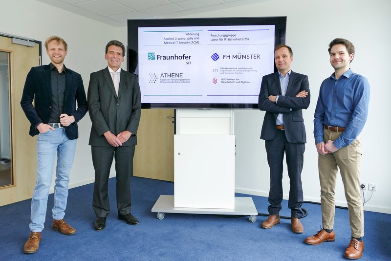 Professor Dr. Frank Dellmann (Präsident der FH Münster, Zweiter von links), und Professor Dr. Sebastian Schinzel (Leiter der neuen Forschungsabteilung des Fraunhofer SIT, Zweiter von rechts) freuen sich über die Kooperation. Dr. Christoph Saatjohann (links) und Fabian Ising, bisher Doktoranden im Labor für IT-Sicherheit der FH Münster, verstärken künftig Schinzels Team. | Foto: FH Münster/Jana Bade 