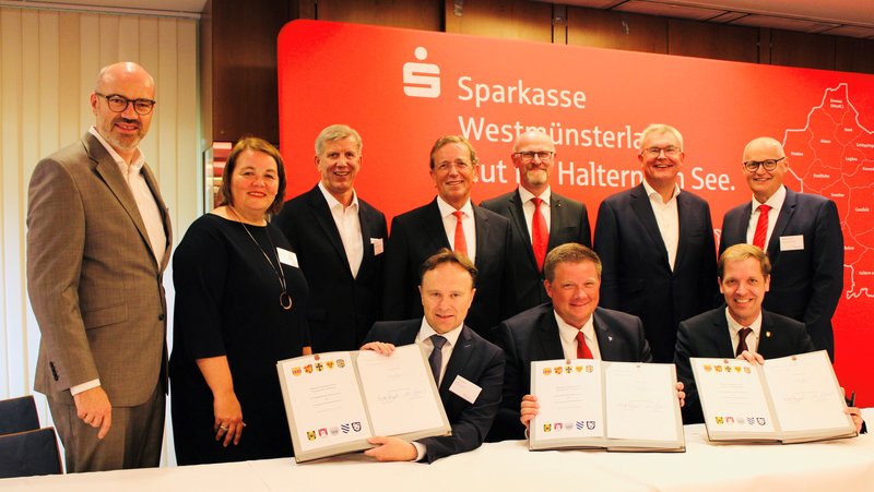 Haben die Fusion besiegelt (sitzend von links): Landrat Dr. Kai Zwicker (Kreis Borken), Halterns Bürgermeister Andreas Stegemann, Landrat Dr. Christian Schulze Pellengahr (Kreis Coesfeld), (stehend von links) Heiko Hüntemann (stellvertretendes Vorstandsmitglied), Christine Erfkämper (Personalratsvorsitzende Stadtsparkasse Haltern am See), Norbert Hypki (Vorstandsmitglied), Heinrich-Georg Krumme (Vorstandsvorsitzender), Olaf Büchter (Vorstandsmitglied Stadtsparkasse Haltern am See), Jürgen Büngeler (Vorstandsmitglied) und Hannes ter Huurne (Personalratsvorsitzender) | Foto: Sparkasse Westmünsterland