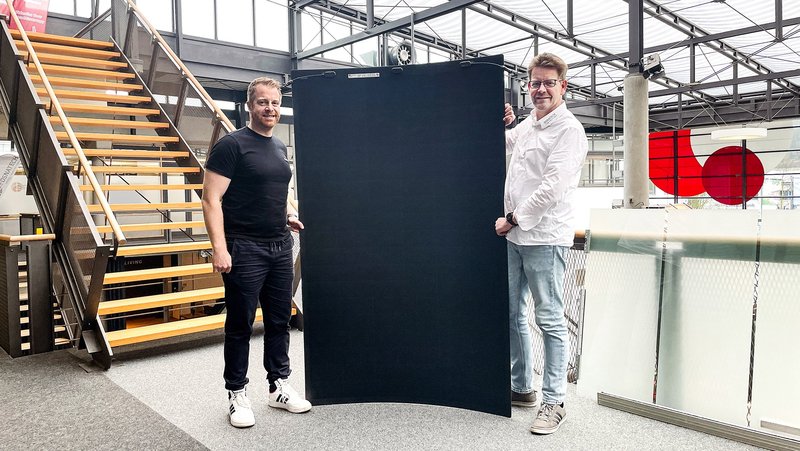 André Schulenberg (WIGOS-UnternehmensService, links) und Malte Sulkiewicz (Osnatech) – hier zu sehen mit einem speziellen, ultraleichten Photovoltaik-Modul für Dächer und Fassaden – arbeiten in Sachen Nachhaltigkeit eng zusammen. Foto: Osnatech